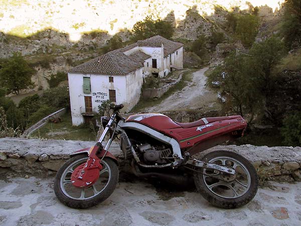 Motorbike on its side near a cliff