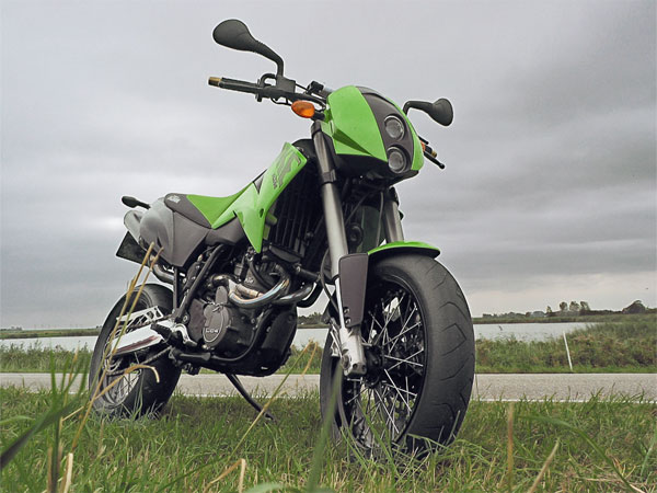 Green KTM Duke, on a dyke