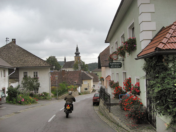 Road through a village with church and flowers
