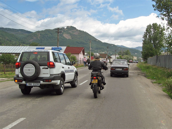 Policecar passing a motorcycle with oncoming traffic