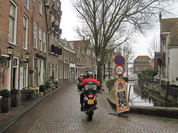 Motorcycles riding alongside a canal