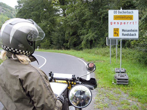 Sign saying gesperrt, photographer seen in a motorcycle