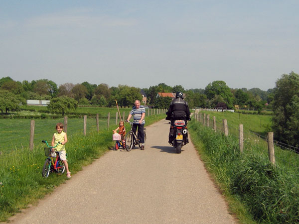 Bicyclists make way for a motorcycle