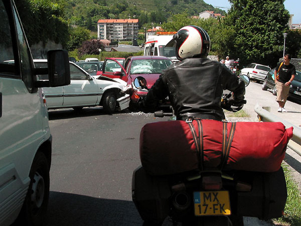 Motorcycle rider confronted with a collision of two cars