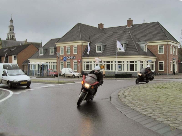 Two motorcycle riders on a wet roundabout