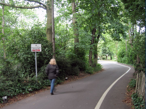 Sylvia walking ans a sign saying SLOW