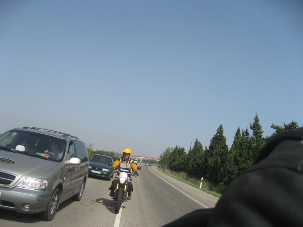 Motorcycle rider rides along a line of cars
