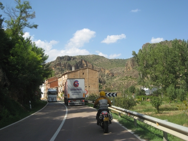 Motorcycle rider behind a truck, and an oncoming truck