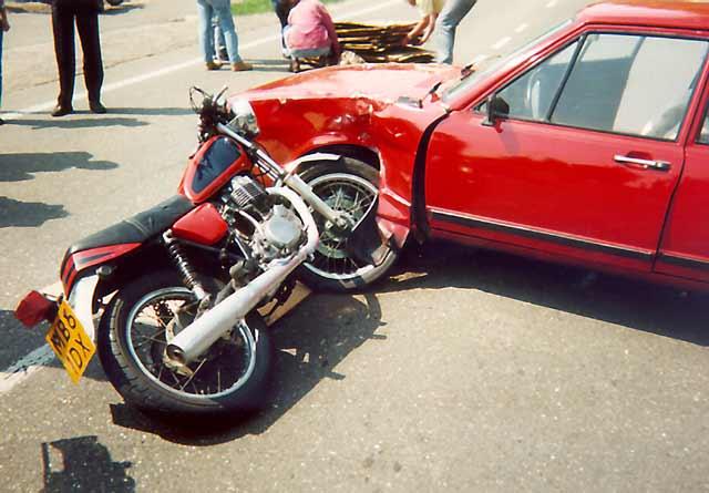 A motorcycle crashed against a car