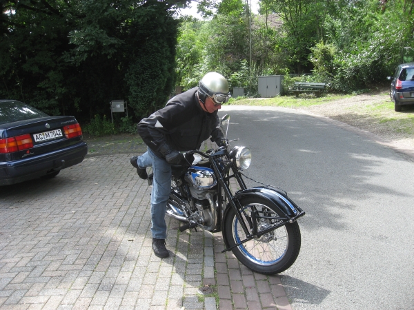An older gentleman on an older motorcycle